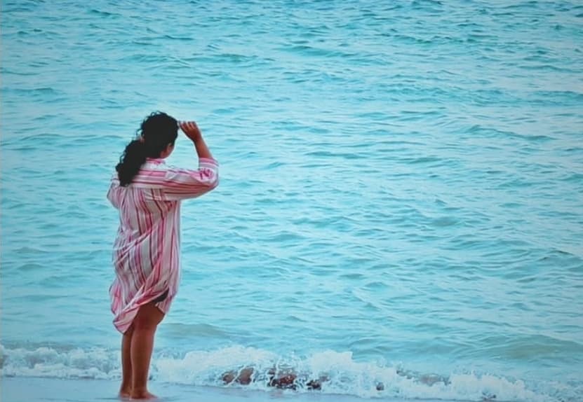 Artist Meenaja Morri looking out at the twilight ocean